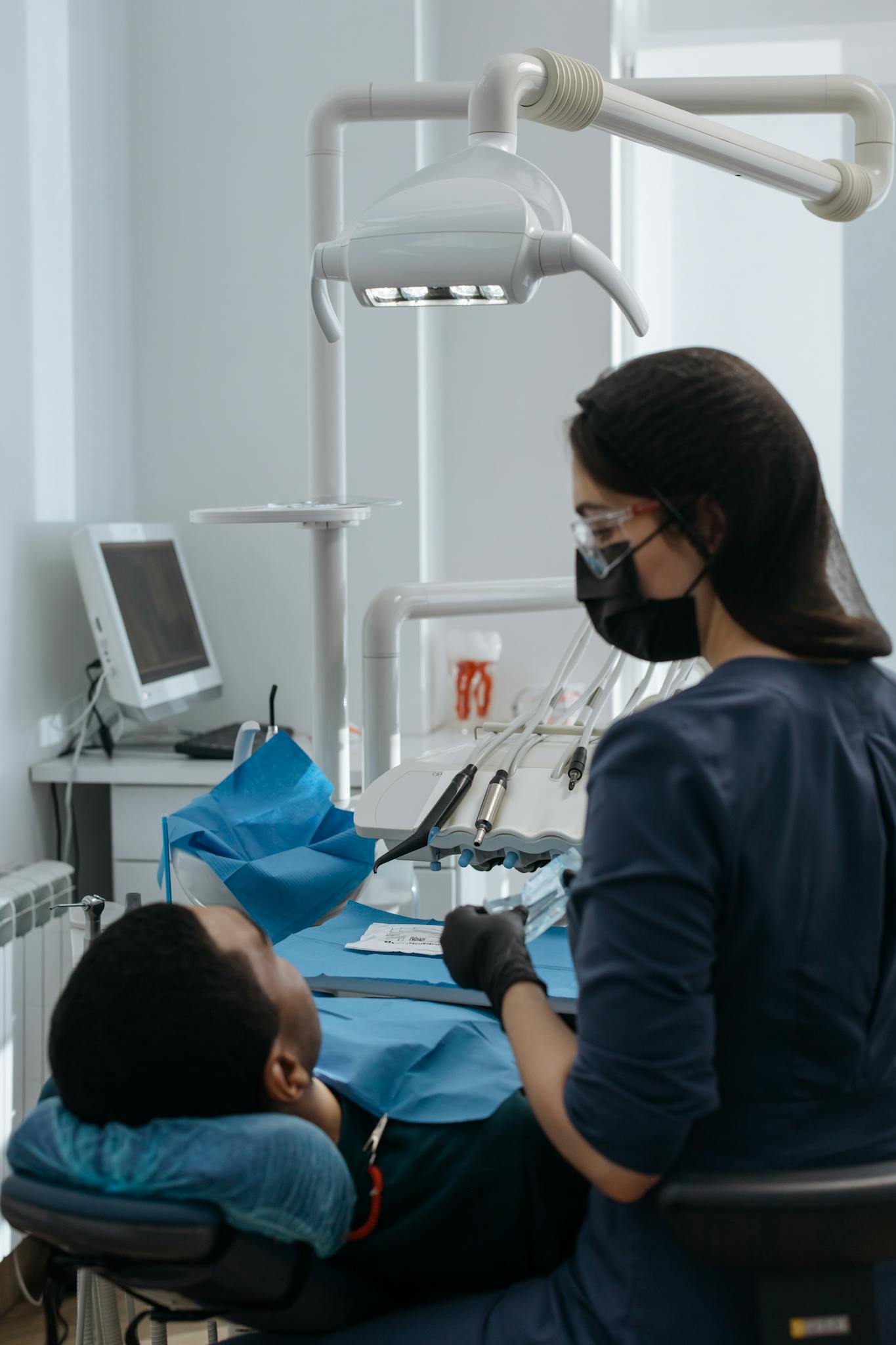 A dentist performing a dental checkup on a patient in a well-equipped, modern clinic.