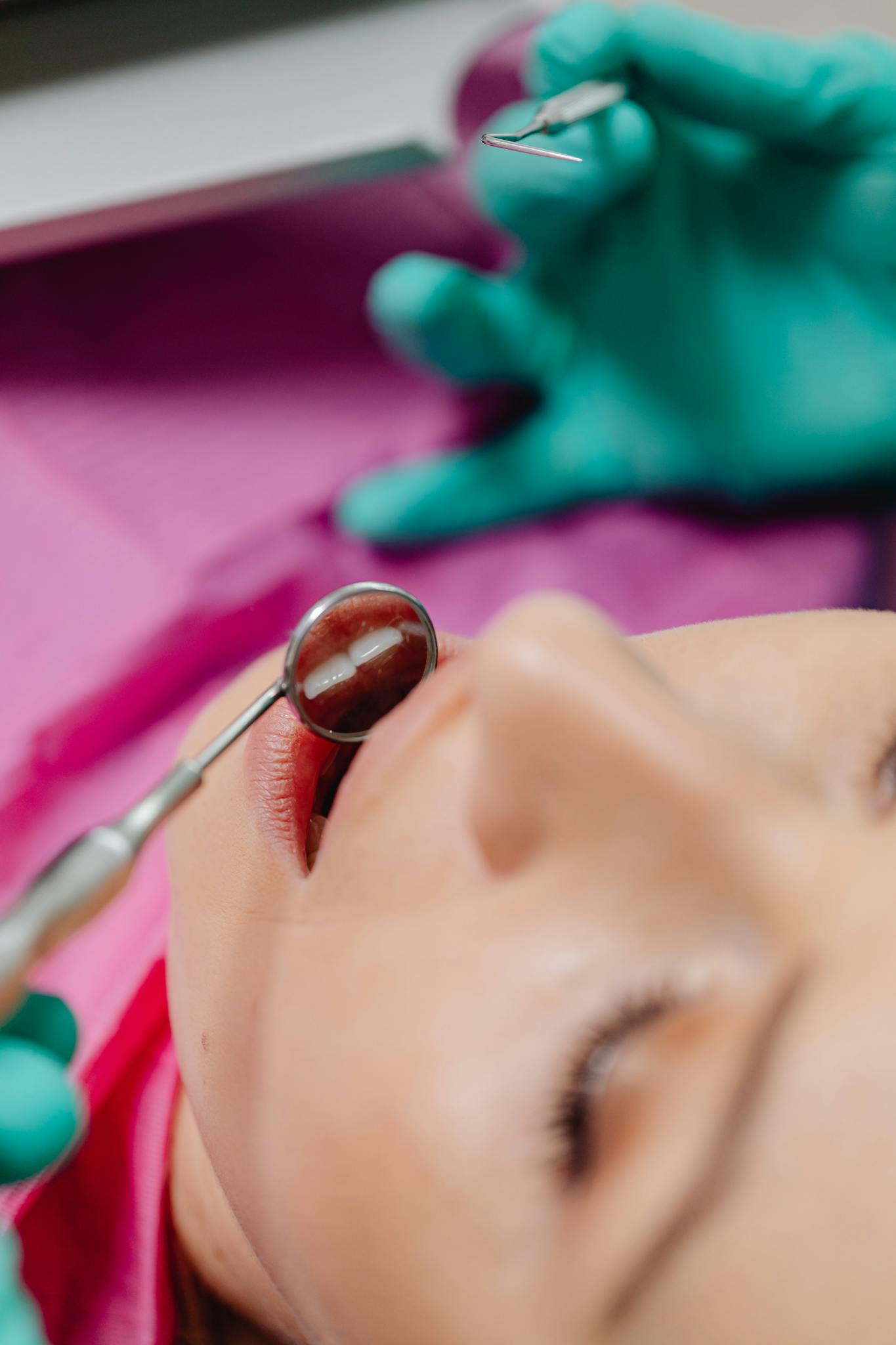A detailed close-up of a dental examination showing a patient and dentist's tools.